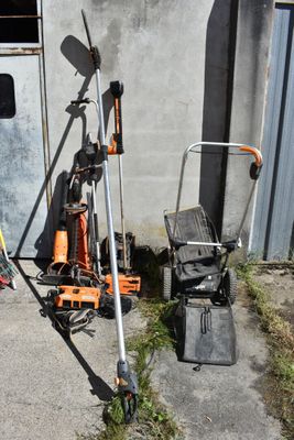a lawn mower and a lawn mower stand in front of a building