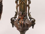 pair of antique bronze vases on marble bases with figures on them