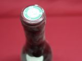 a bottle of wine that is sitting on a red cloth