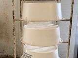 a metal cart with a stack of white dishes on it