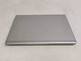 a silver laptop sitting on a white sheet on a bed