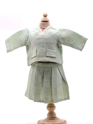 ensemble chemise et jupe à carreaux verts et blancs, présenté sur un mannequin en bois