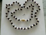 a necklace made of pearls and garnetts on a table