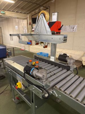un tapis roulant dans une usine, sur lequel se trouve une machine