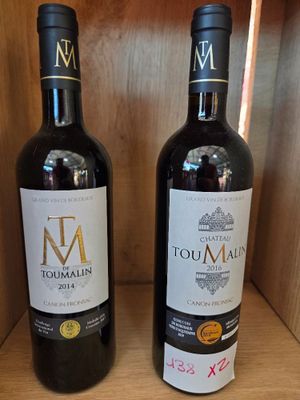 deux bouteilles de vin posées sur une étagère en bois