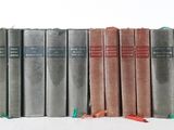 several books are stacked on top of each other on a white surface