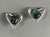 une paire de boucles d'oreilles en argent en forme de cœur, ornées d'une pierre bleue