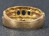 a close up of a gold ring with a black dot in it