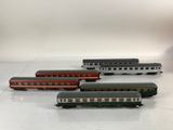 several toy trains are lined up in a row on a white surface