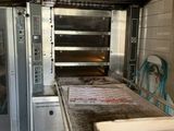 a box of pizza sitting on a counter in front of an oven