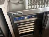 a wine cooler with a basket on top of it in a kitchen