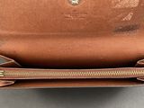 the inside of a brown purse with a zipper open