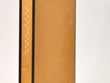 an old book sitting on top of a white table next to a white wall