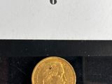 a close up of a gold coin in a display case