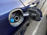 a blue car with a gas pump attached to it ' s side