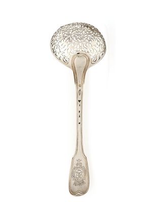 une cuillère ancienne en argent sur fond blanc, ornée d'un motif floral