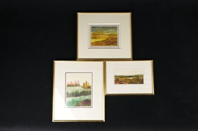 trois tableaux encadrés représentant un paysage, accrochés au mur au-dessus d'un lit