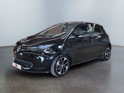 La voiture noire est garée dans une pièce blanche au sol noir.