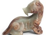 une figurine représentant un chien assis sur une surface blanche