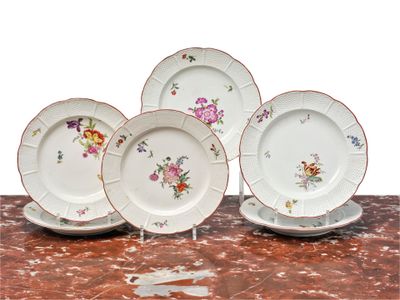four plates with flowers on them sitting on a table