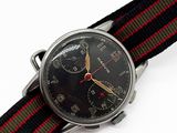 une montre avec un cadran noir et un bracelet rouge et vert