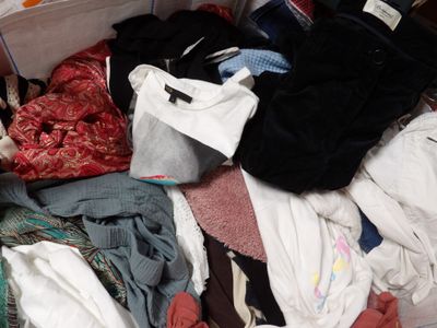 a suitcase full of clothes and clothes sitting on the floor