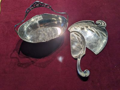 un bol en argent et une cuillère en argent posés sur une nappe rouge