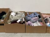 trois boîtes contenant des peluches, posées par terre