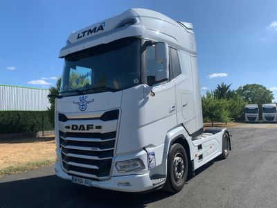 un camion blanc garé sur le bord de la route