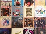 many different album covers on the wall of a room