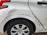 a white car that has been damaged and is parked on the side of the road
