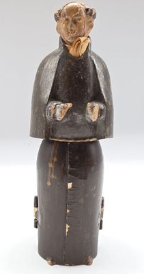 une vieille figurine en bois représentant un homme avec un chapeau sur la tête