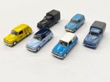 several toy cars are lined up in a row on a white surface