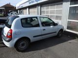 a small white car parked in front of a building