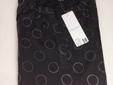 un gros plan sur un pantalon noir orné de cercles blancs