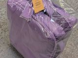 a purple suitcase wrapped in plastic on the floor