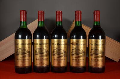 four bottles of wine are lined up on a red table