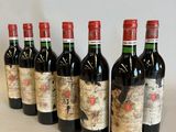 six bottles of red wine lined up in a row on a table