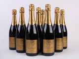 six bouteilles de champagne alignées sur une surface blanche
