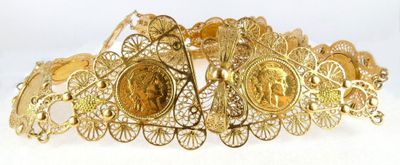 a close up of a gold bracelet on a white surface