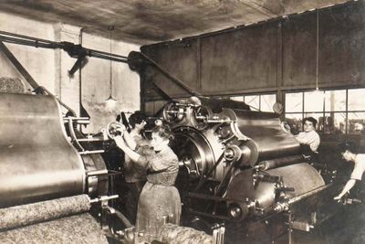 black and white photograph of a group of women working in a factory