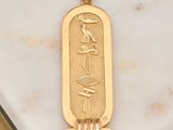 an image of a gold plated pendant with an egyptian hierole on it