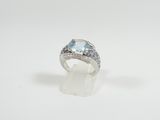 a close up of a ring with a blue topaz stone surrounded by blue and white diamonds