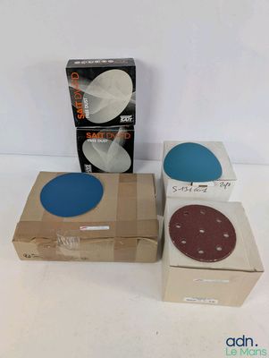 deux boîtes de sable et une boîte de disques posées sur une surface blanche