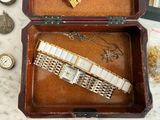 a wooden box with a watch inside of it on a table