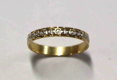 gros plan d'une bague en or avec des diamants sur une surface blanche