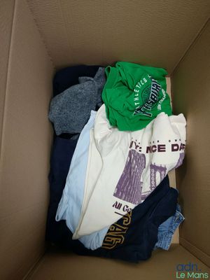 a cardboard box filled with clothes and a t - shirt