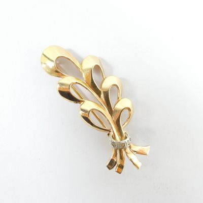 gold plated brooch with a leaf motif and a diamond center