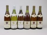 six bouteilles de vin alignées sur une surface blanche