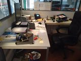 un chat assis sur un bureau, à côté d'une chaise